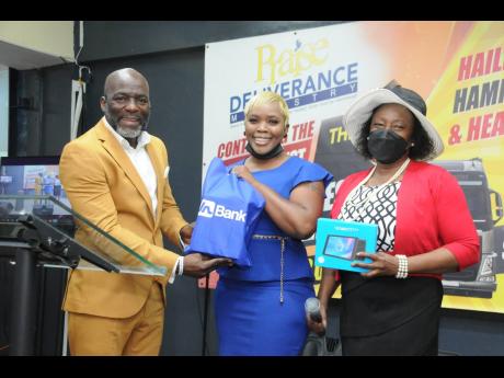 Belinda Reid-Marshall (centre), president of the JN Circle Corporate Area chapter, presents Pastor Fitzroy Kerr of the Praise Deliverance Ministry church in Kingston with tablets that were purchased for students attending the church. Sharing in the moment is Jennifer Clarke-Twiddle, business relationship & sales adviser at JN Bank.