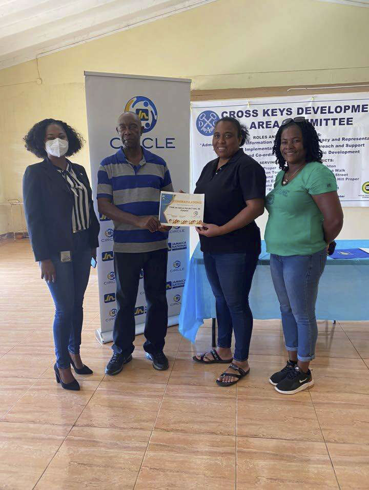 Mandeville Jamaica National (JN) Circle President Wendy Freckleton (second right) presenting a funding approval certificate to Cross Keys Development Area Committee Chairman Smeadley Reid (second left) at the Cross Keys Community Centre recently. With them are Venessa Dillon-Hendricks (left), client relationship officer for Jamaica National Bank’s Mandeville and Christiana branches; and Nicole Clarke, member of the Mandeville JN Circle.